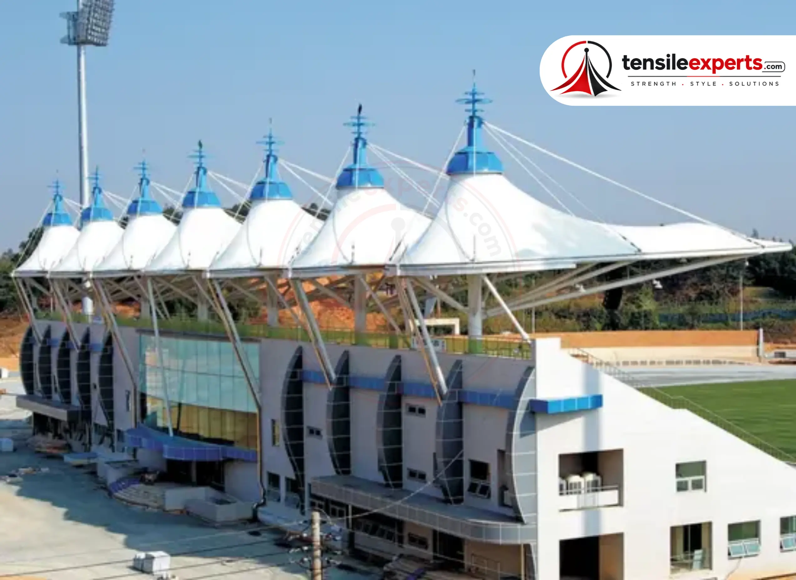 A tensile roof with distinctive spired masts over a spectator stand — the same design vocabulary scales down for enclosed court coverage.
