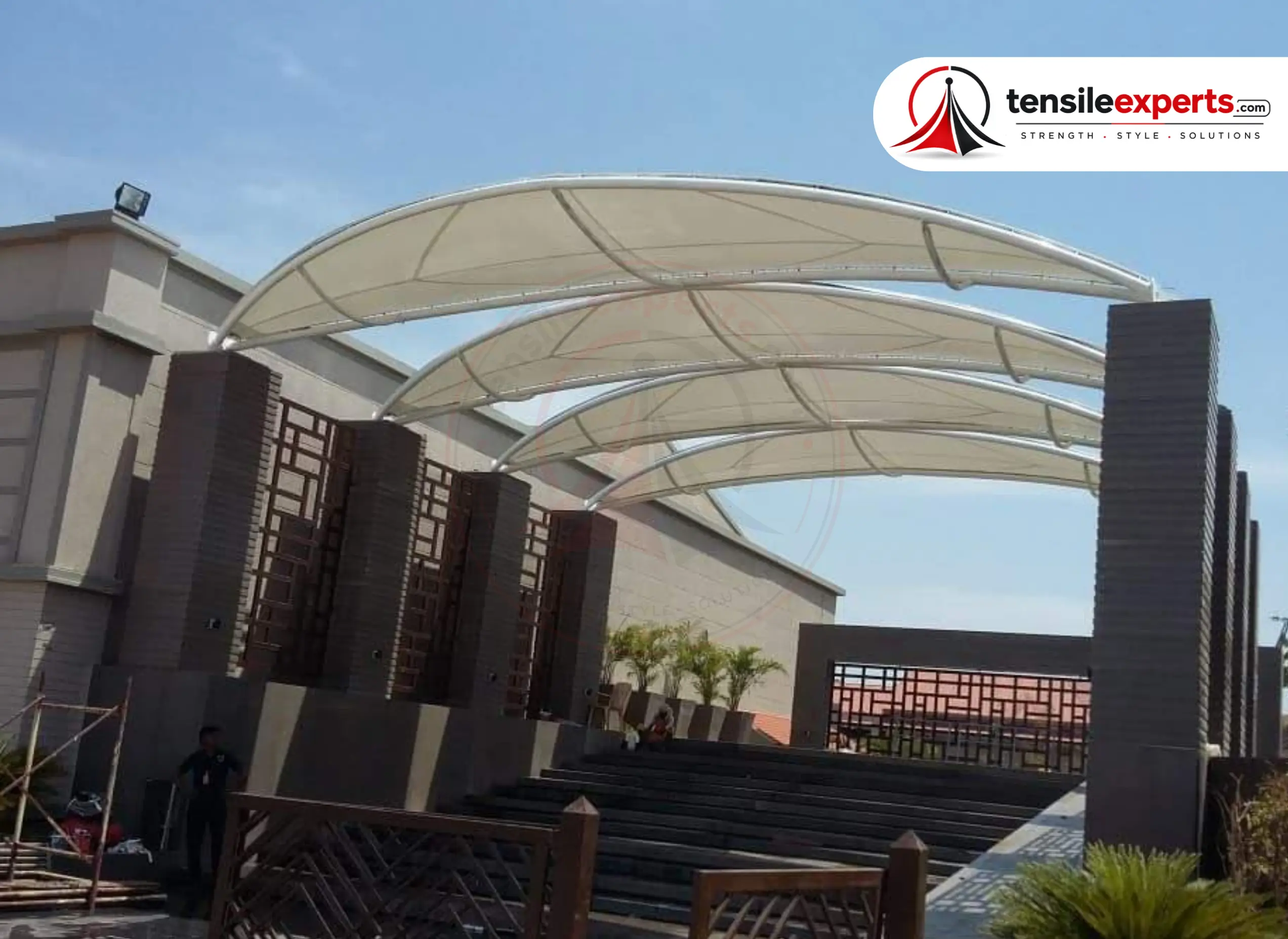 A multi-arch tensile entrance canopy over a stepped amphitheater entry.