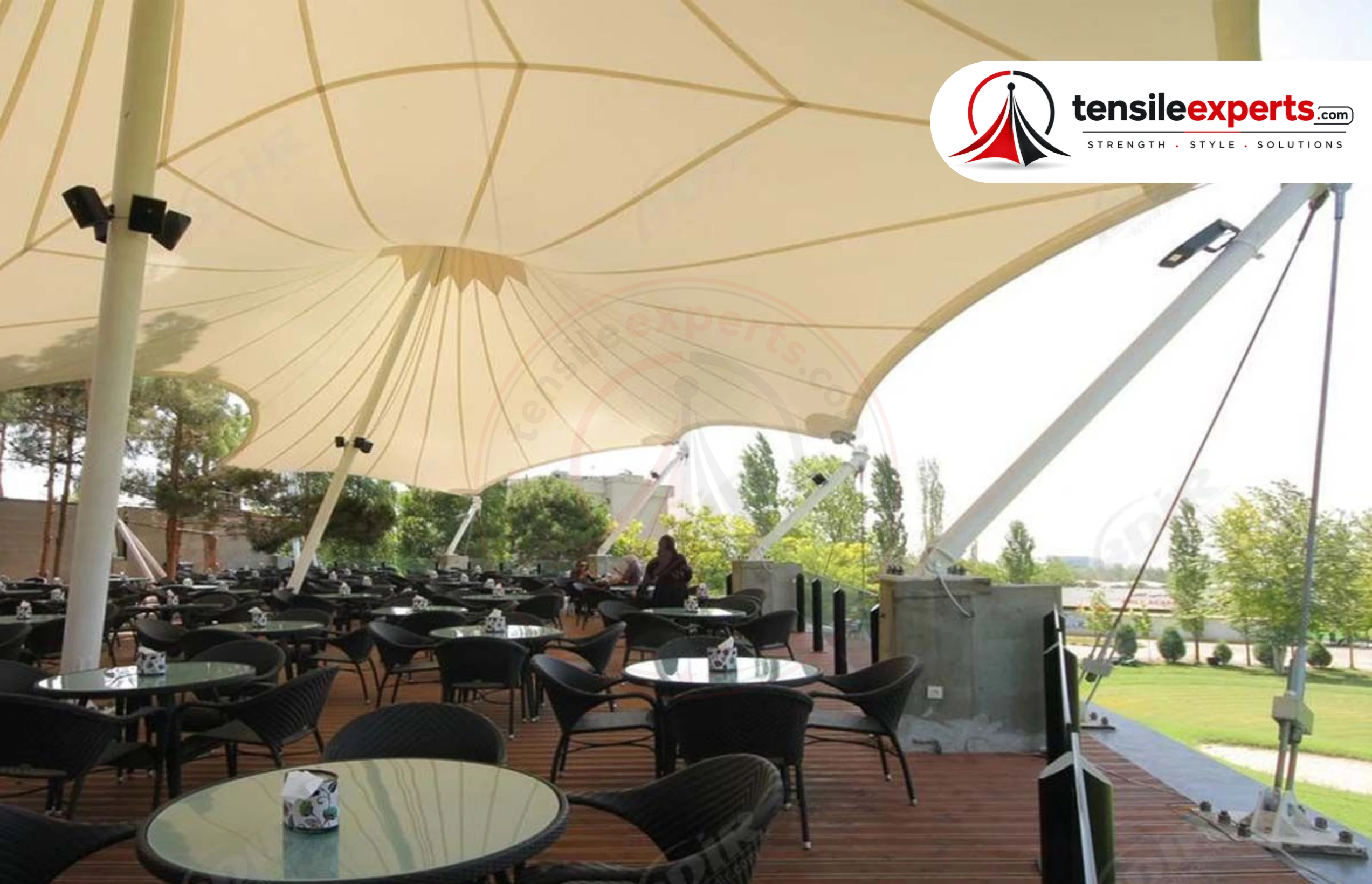 A tensile food court structure covering an outdoor dining seating area.