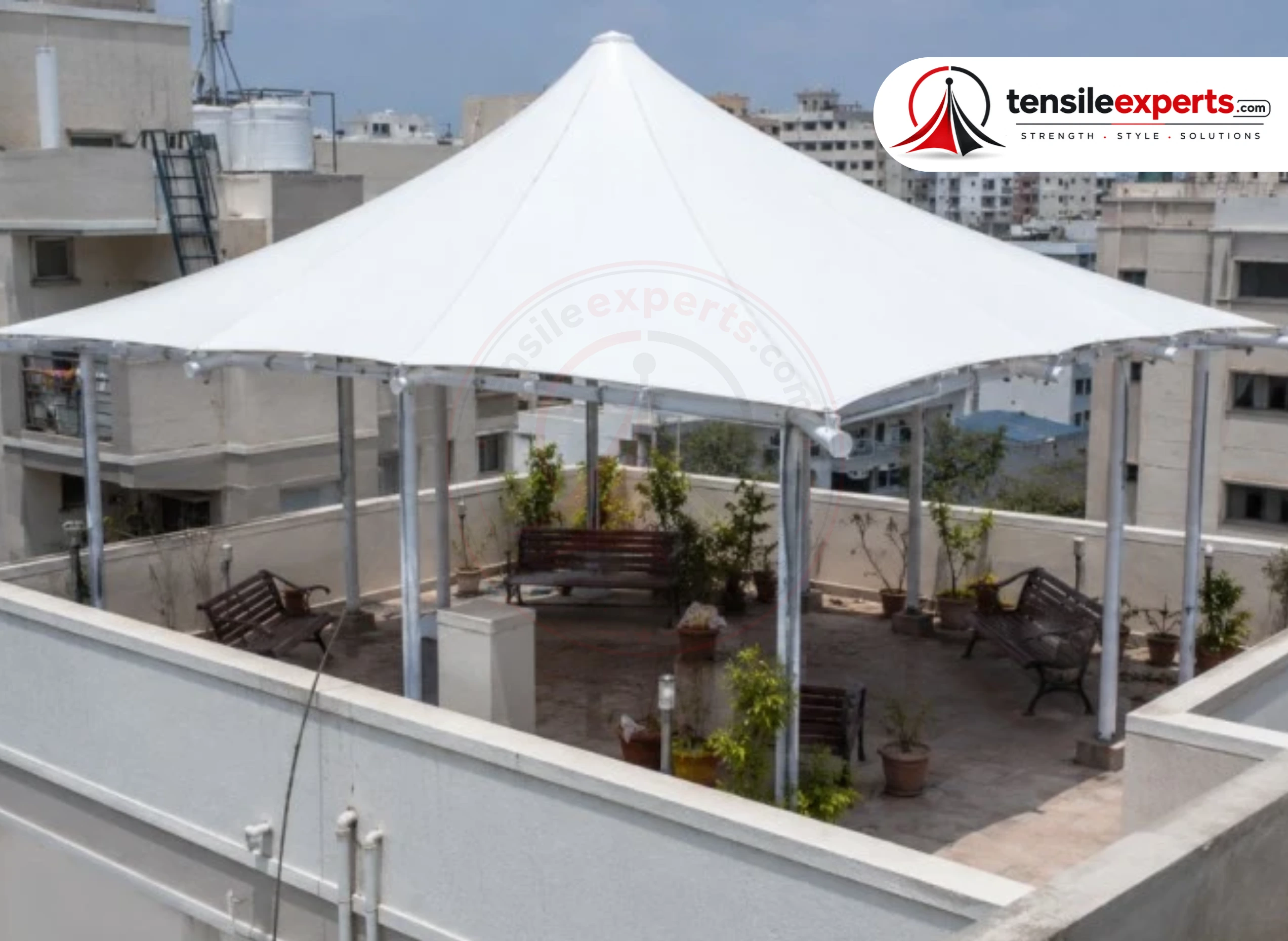 A freestanding tensile gazebo placed independently in a garden setting.