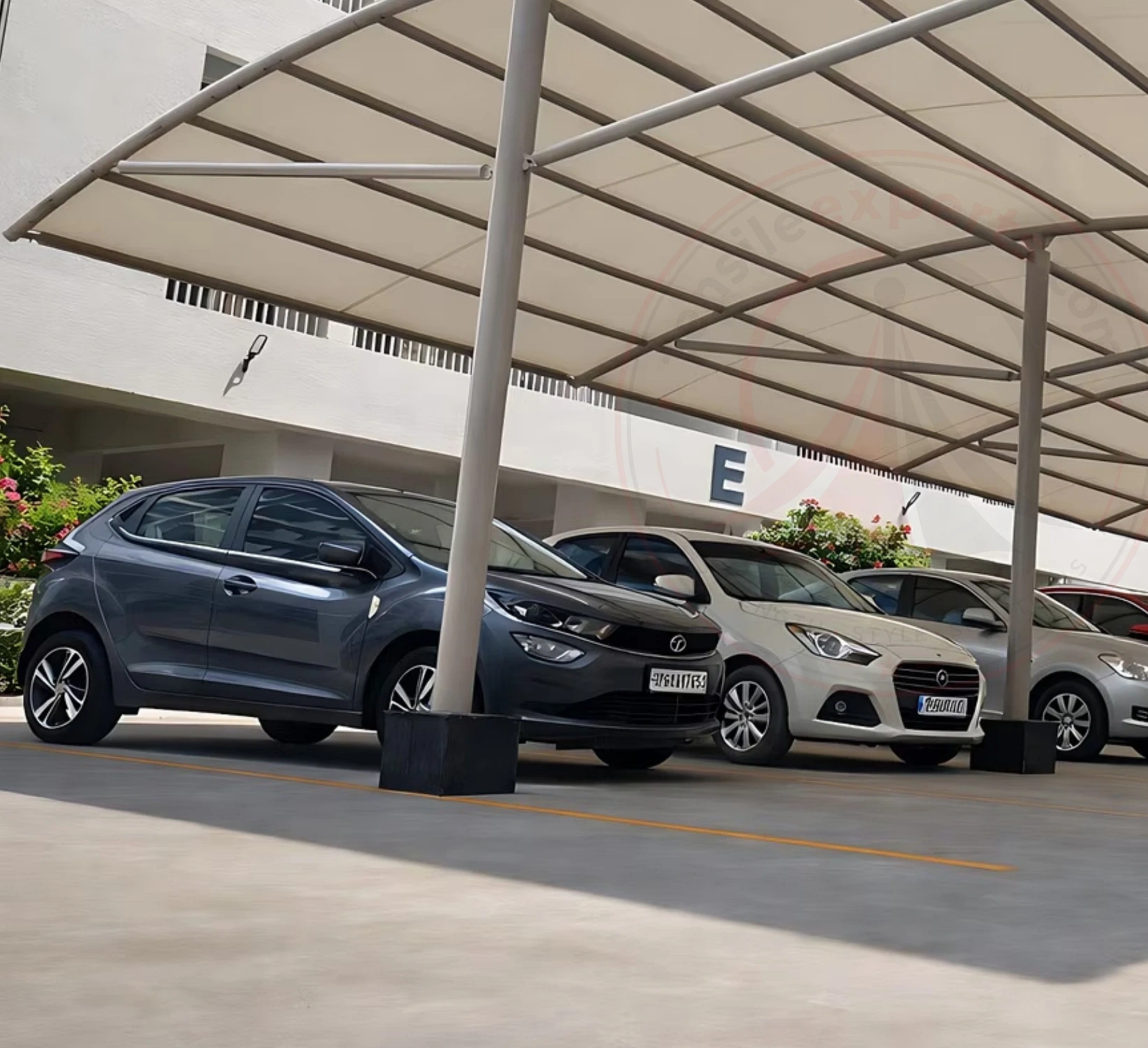 Cantilever tensile parking canopy covering multiple vehicle bays