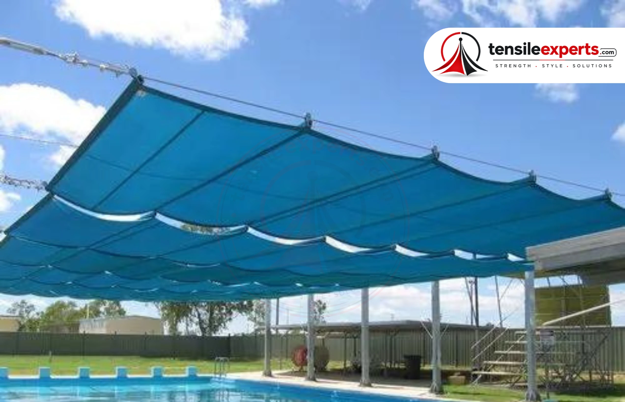 Retractable shade structure over an outdoor swimming pool